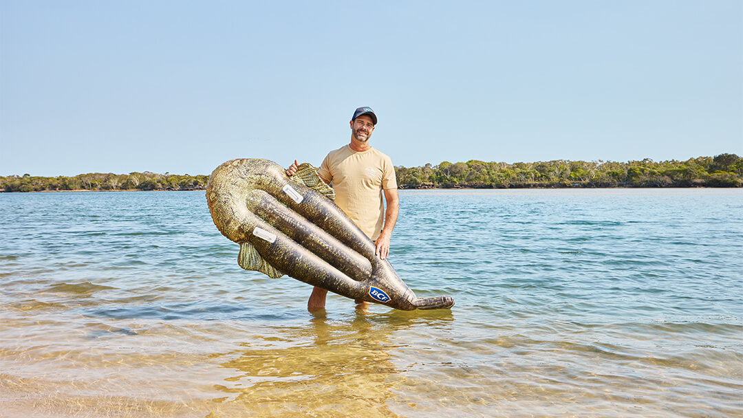 Man standing in water with inflatable flathead