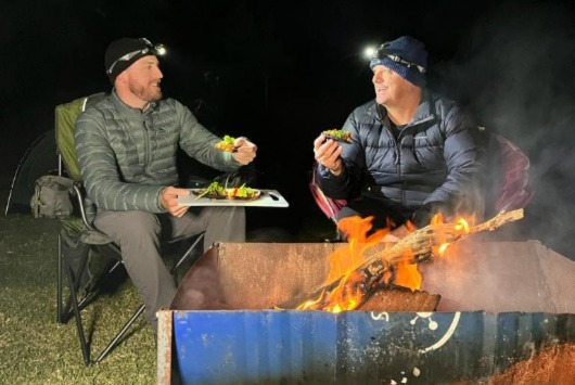 Harry and Scotty cooking up a feast in their macpac jackets