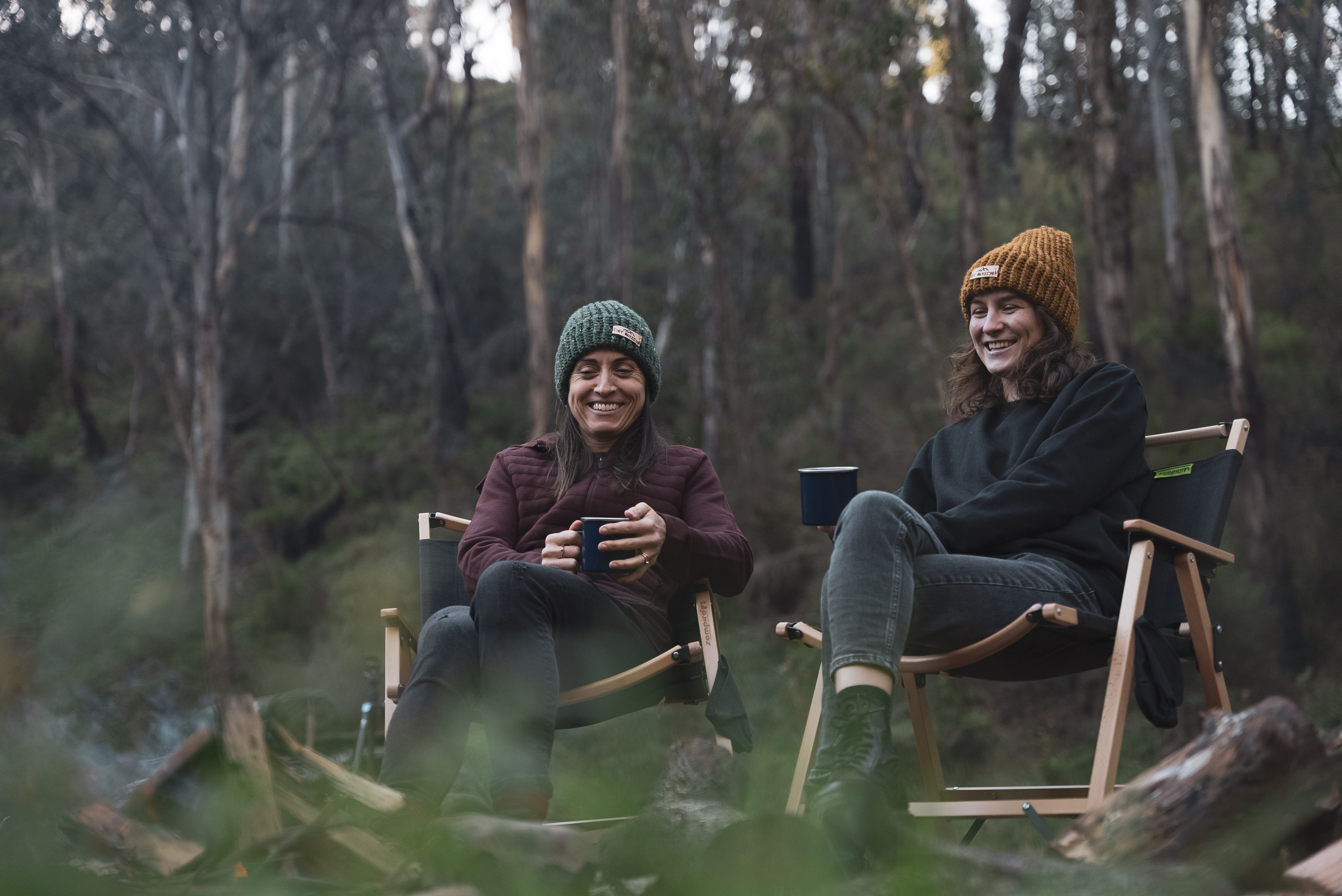 Brooke and Lynsday from Hipcamp enjoying a cuppa around the campfire at Rhapsody with Zempire Roco low rider chairs