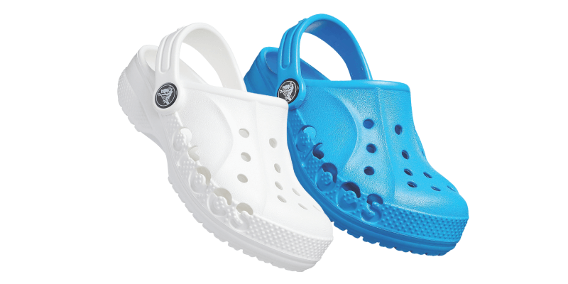 Pair of Crocs shoes sitting on the sand