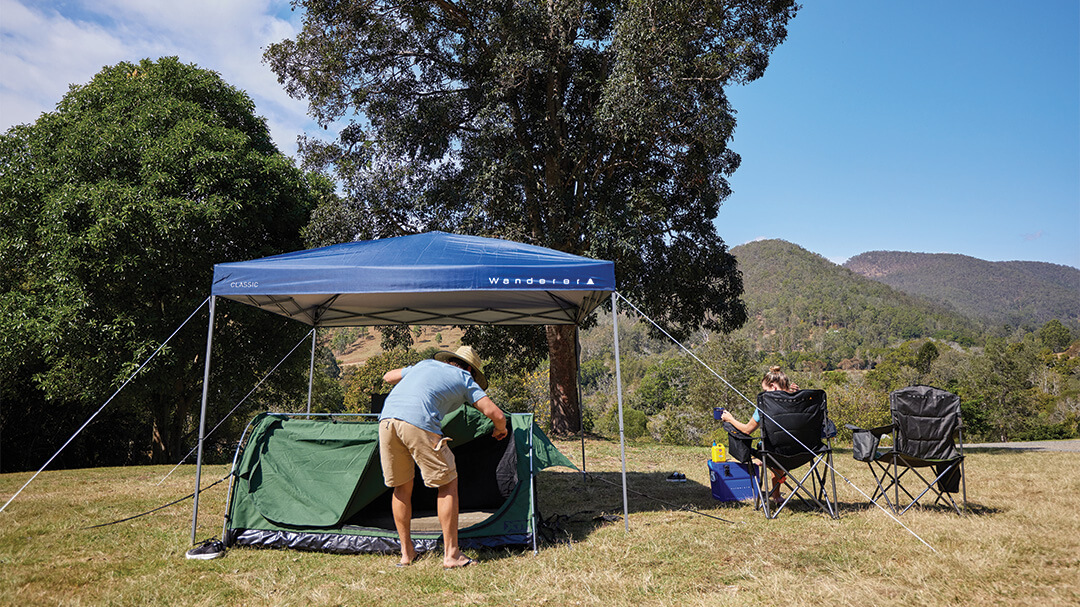 Man setting up gazebo at camp