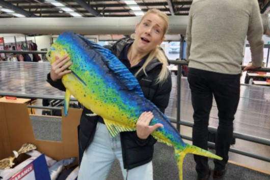 Mary wearing her macpac jacket while juggling a giant fish pillow